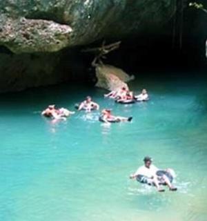 a group of people swimming in a cave in the water