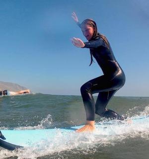 a woman riding a wave on a surfboard in the ocean