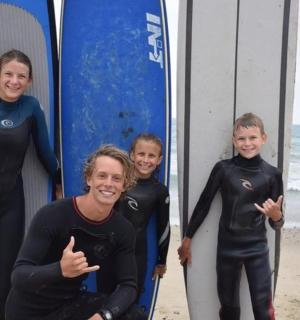 a group of people standing on the beach with surfboards