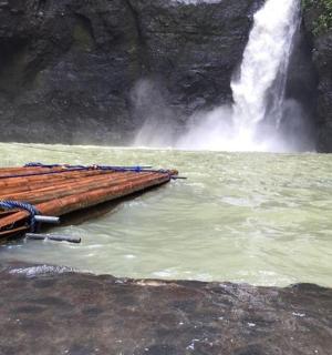 a boat in the water next to a waterfall