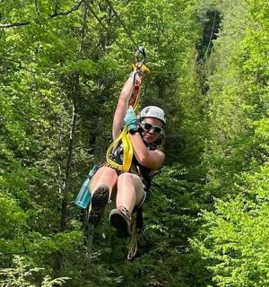 a woman is zip lining through the trees