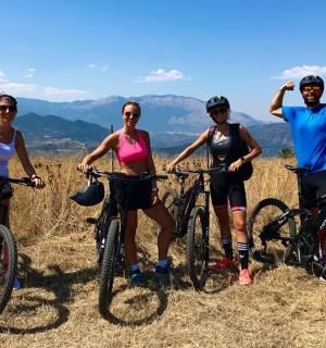 a group of people standing with bikes on a hill