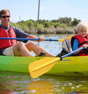 一名男子和一名男孩在水上划皮艇