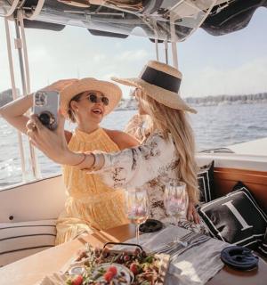 two women sitting on a boat taking a picture