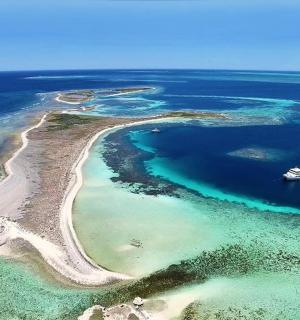 海洋中的一个岛屿，水中有一艘船