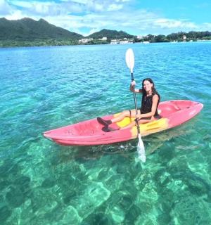 a woman sitting on a pink kayak in the water