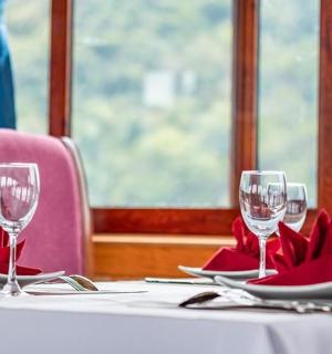 a table with two wine glasses and red napkins