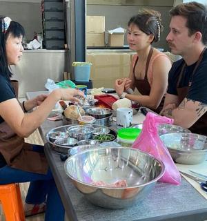 a group of people sitting at a table preparing food