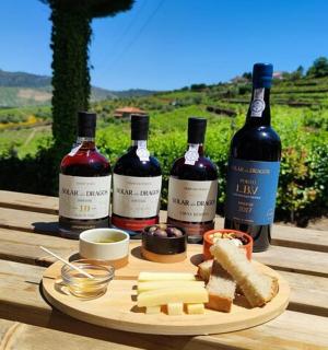 three bottles of wine and cheese on a wooden table