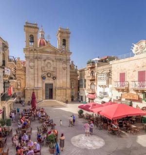 skupina lidí stojících na náměstí před budovou