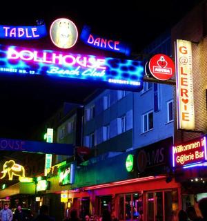 a city street at night with neon signs