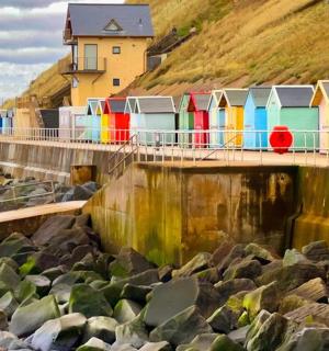 a row of colorful beach huts on a pier
