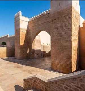 a brick wall with an arch in a courtyard