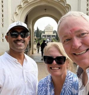 两名男子和一名女子站在一栋建筑物前