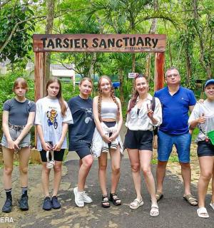 un gruppo di persone in piedi davanti a un cartello