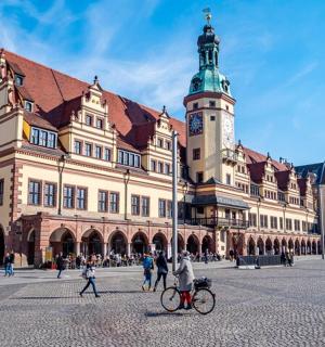 ein großes Gebäude mit einem Uhrenturm und einer Person auf einem Fahrrad