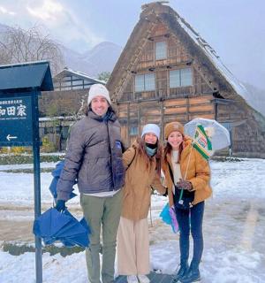 三个人站在公交车站的小屋前