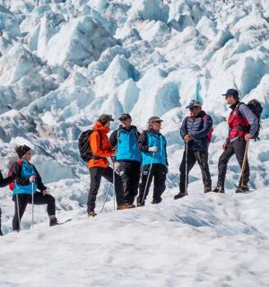 a group of people standing on top of a glacier