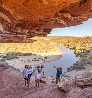 一群人穿过河边的洞穴