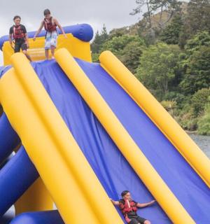 skupina lidí jedoucí na nafukovací skluzavce