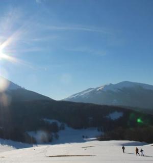un gruppo di persone che sciano lungo un pendio innevato