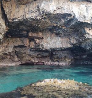 una piscina di acqua blu accanto a una scogliera rocciosa