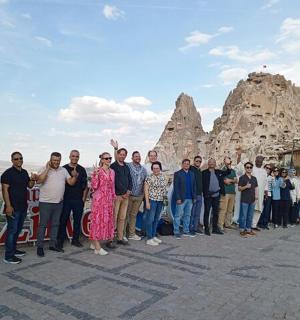 a group of people standing in front of a rock formation