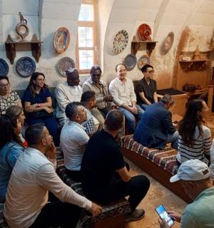 a group of people sitting in a room with plates