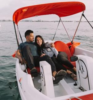 muž a žena sedící na lodi ve vodě