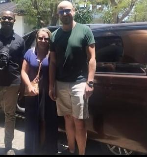 三个人站在一辆车旁边