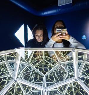 a man and a woman taking a picture in a mirror