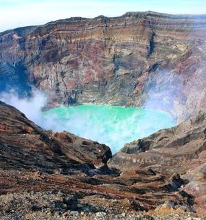 an aerial view of a mountain with a green eruption
