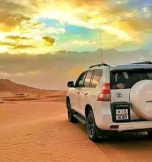 a white suv driving through the desert