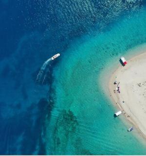 an overhead view of a beach with boats in the water