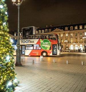 a double decker bus parked next to a christmas tree