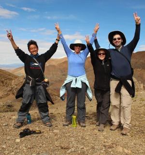 skupina lidí stojící na vrcholu hory