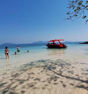 a group of people standing in the water near a boat