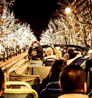 a group of people riding on a bus with christmas lights