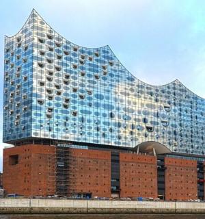 a tall glass building on top of a brick building