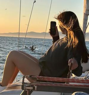 a woman sitting on a boat taking a picture
