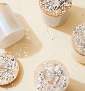 three donuts with sprinkles in a container on a table