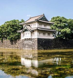 a building sitting on top of a wall in the water