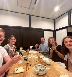 一群人坐在桌边吃寿司