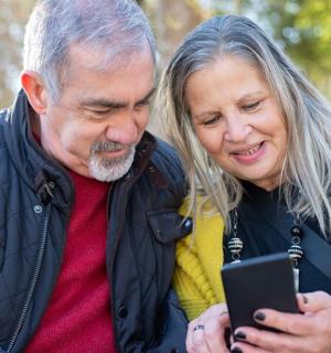 a man and a woman looking at a cell phone