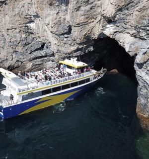 skupina lidí na lodi v jeskyni