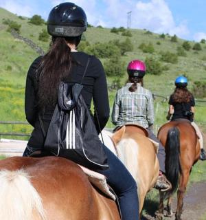 一群人骑着马沿着土路行驶