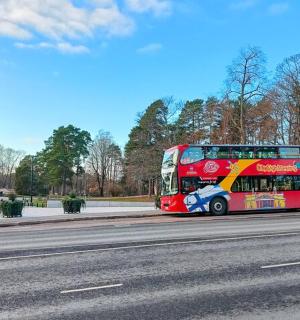 rauður tvíhæðarrúta ekur niður götu