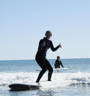 muž jedoucí na vlně na surfovém prkně v oceánu