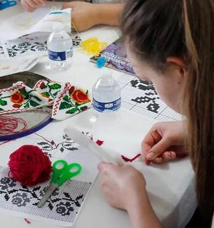 a young girl cutting out a piece of paper with scissors