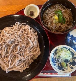 a table with two black plates of noodles and cups